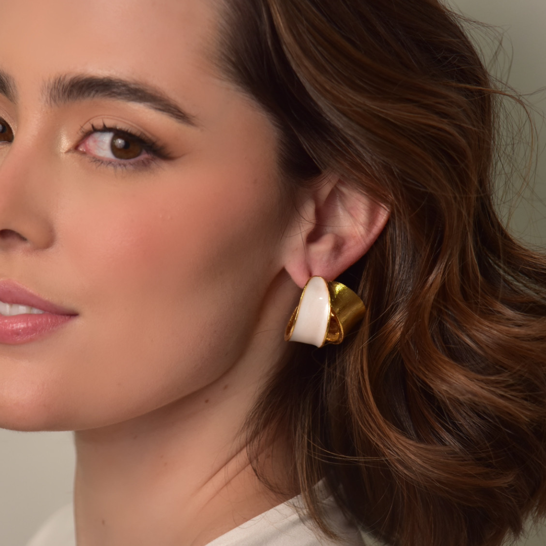 The Bermeo Hoop earrings are handmade by Colombian artisans in bronze with 24-karat gold plating an enamel finish.