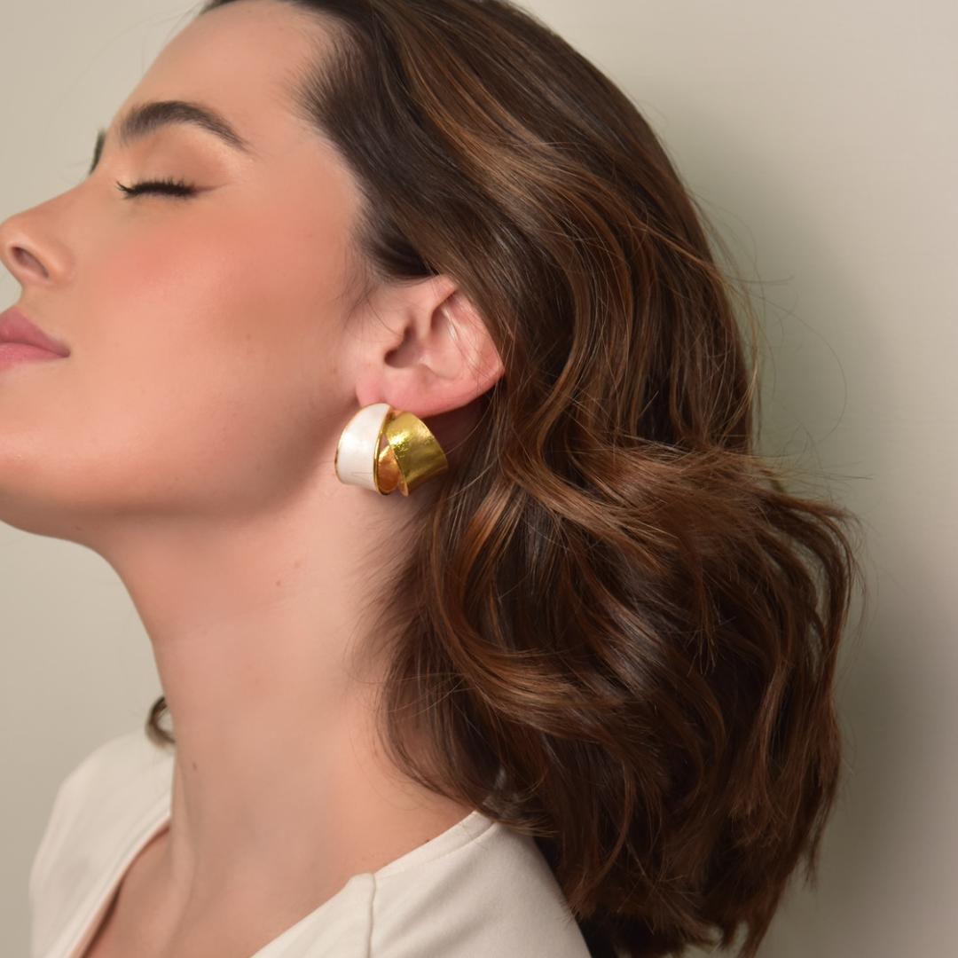 The Bermeo Hoop earrings are handmade by Colombian artisans in bronze with 24-karat gold plating an enamel finish.