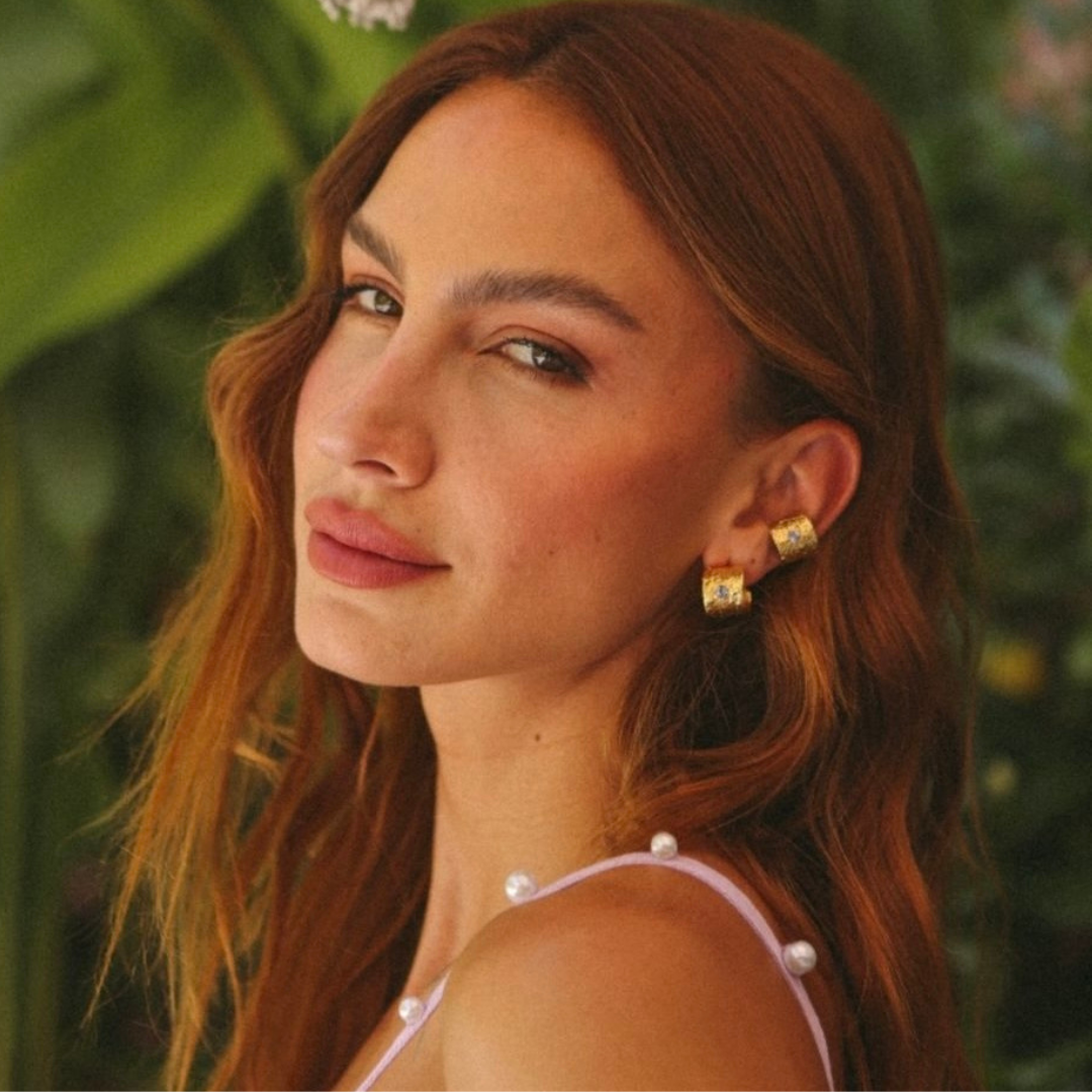 The Croma Hoop earrings are handmade by Colombian artisans in bronze with 24-karat gold plating and zirconia